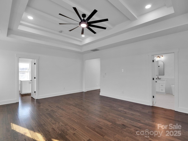 unfurnished living room with ceiling fan, dark hardwood / wood-style floors, and a raised ceiling