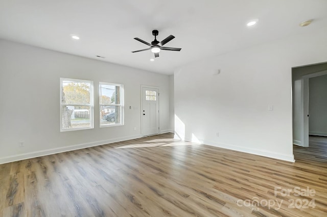 unfurnished living room featuring ceiling fan and light hardwood / wood-style flooring