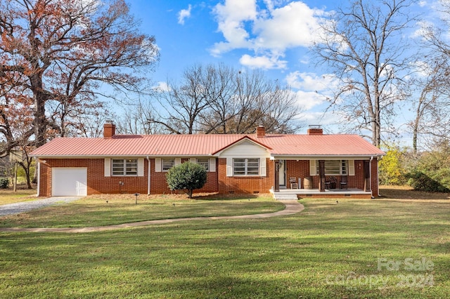 ranch-style house with covered porch, a front yard, and a garage