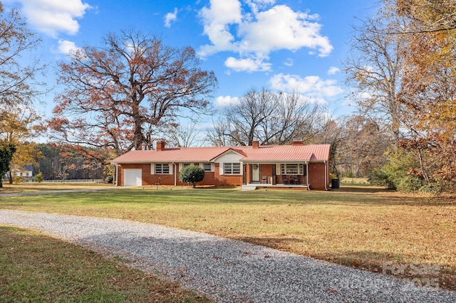 ranch-style home featuring a garage, a front lawn, and covered porch