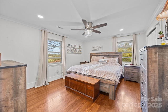 bedroom with wood-type flooring, ornamental molding, and ceiling fan