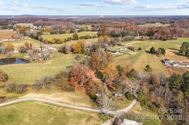 birds eye view of property featuring a water view and a rural view