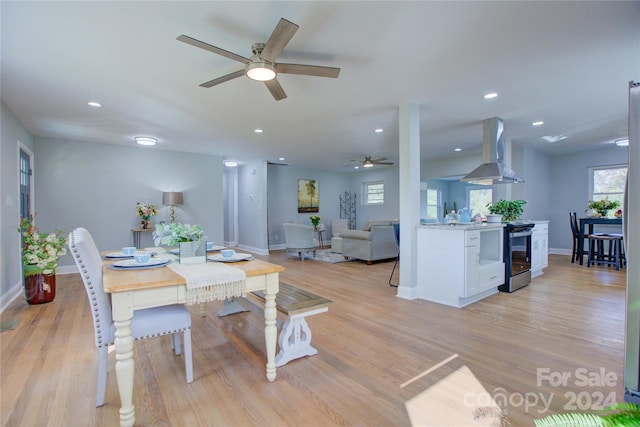 dining space with ceiling fan and light wood-type flooring