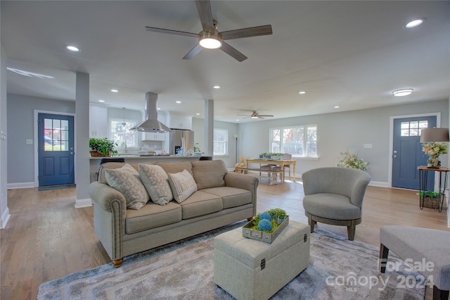 living room with ceiling fan, light wood-type flooring, and sink