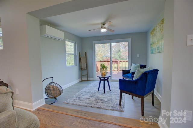 sitting room featuring ceiling fan, hardwood / wood-style floors, and a wall mounted air conditioner