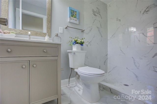 bathroom featuring tiled shower, vanity, and toilet