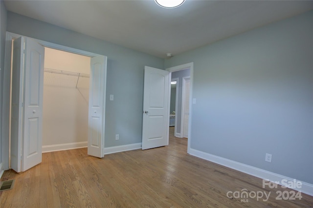 unfurnished bedroom with light hardwood / wood-style floors and a closet