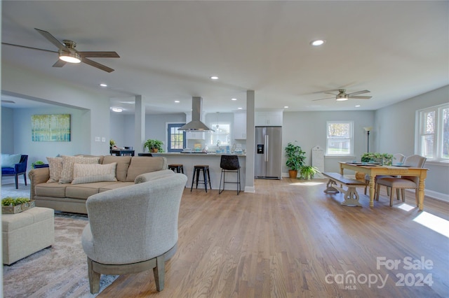 living room featuring ceiling fan, sink, and light hardwood / wood-style floors