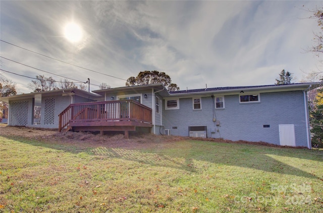 rear view of house featuring a lawn and a deck