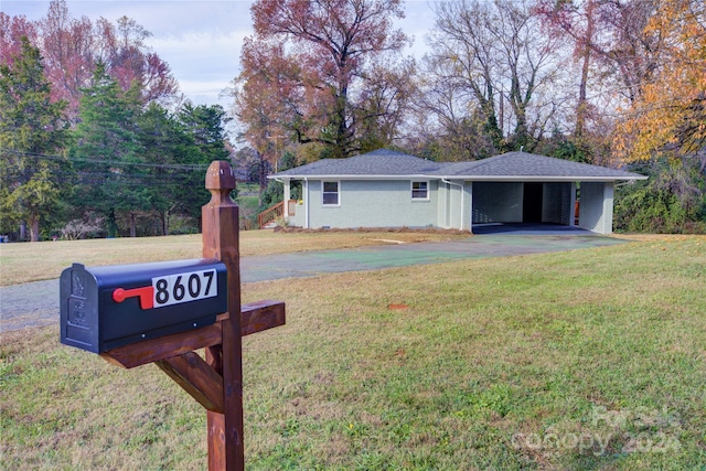 ranch-style house featuring a front lawn and a carport