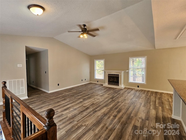 unfurnished living room with ceiling fan, dark hardwood / wood-style flooring, a textured ceiling, and vaulted ceiling