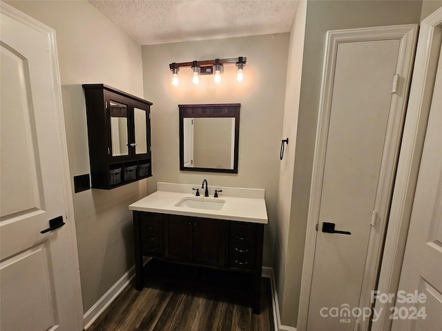 bathroom featuring vanity, a textured ceiling, and hardwood / wood-style flooring