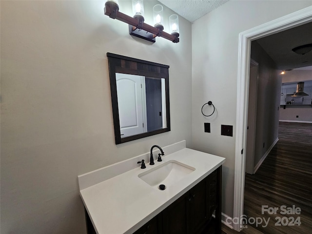 bathroom with a textured ceiling, vanity, and hardwood / wood-style flooring