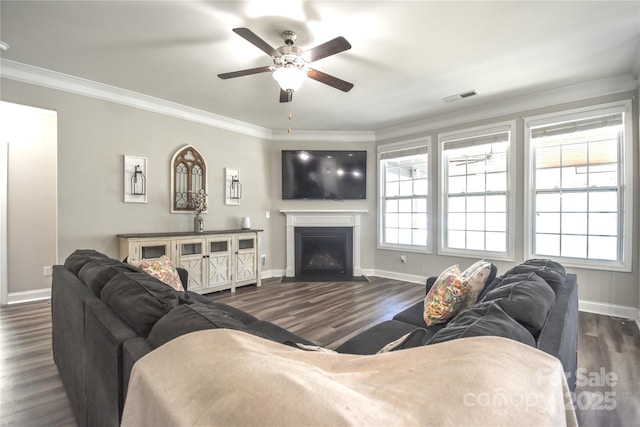 living room with crown molding, dark wood-type flooring, and ceiling fan