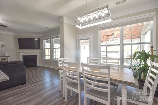 dining space featuring crown molding, dark wood-type flooring, and ceiling fan