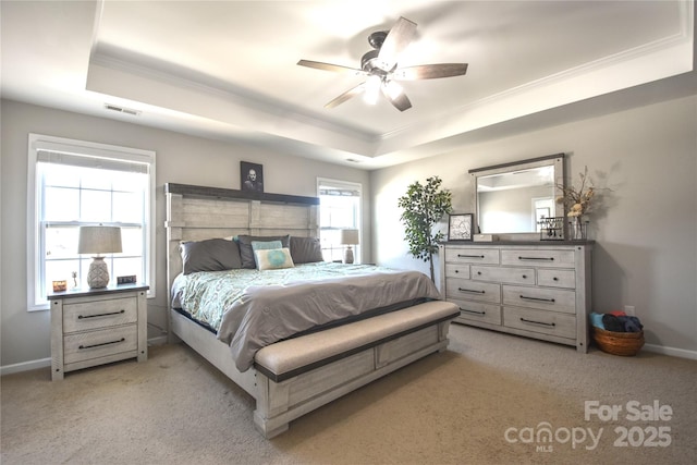 bedroom featuring a raised ceiling, crown molding, light colored carpet, and ceiling fan