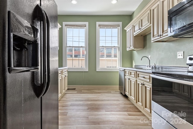 kitchen with cream cabinetry, light hardwood / wood-style floors, sink, and appliances with stainless steel finishes