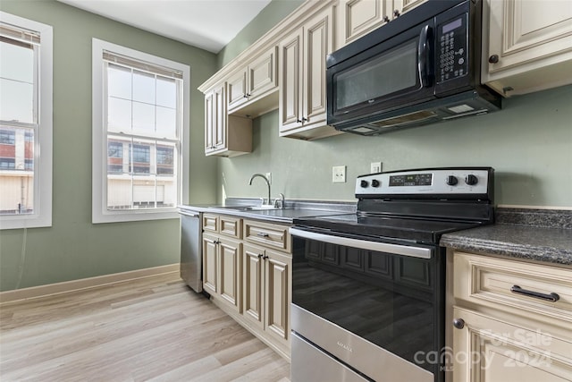 kitchen featuring light hardwood / wood-style floors, sink, stainless steel appliances, and cream cabinets