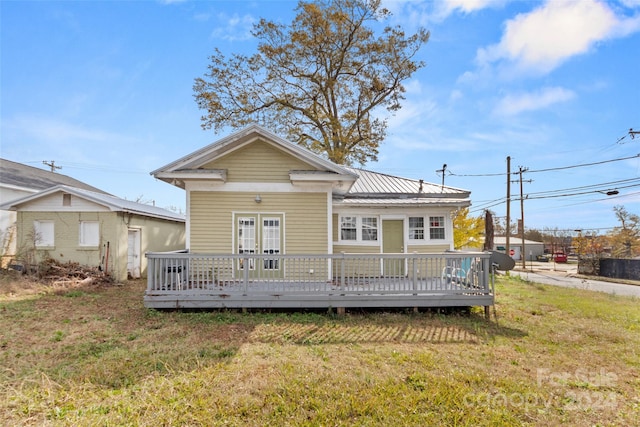 rear view of house with a deck and a yard