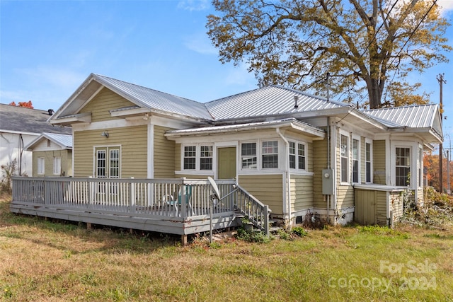 back of house with a lawn and a deck