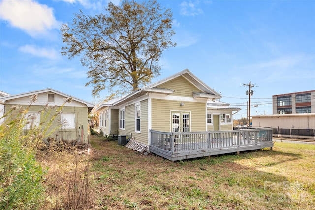 back of house featuring a yard, a wooden deck, and central AC