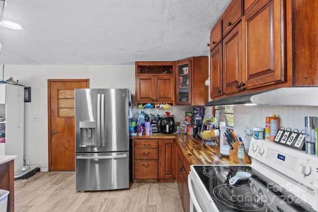 kitchen featuring stainless steel fridge, a textured ceiling, and electric stove