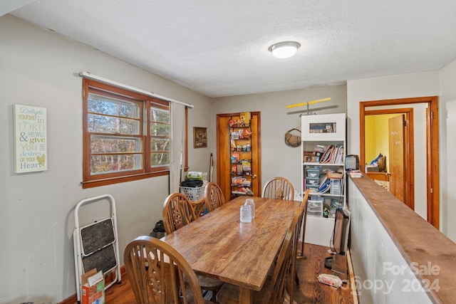 dining area featuring a textured ceiling and dark wood-type flooring