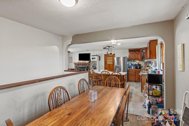 dining room featuring a textured ceiling, light wood-type flooring, and sink