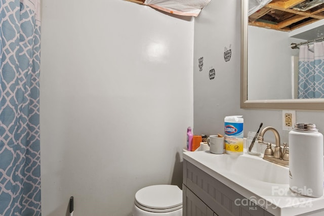 bathroom featuring walk in shower, vanity, and toilet