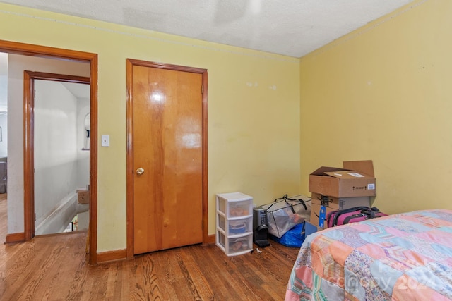 bedroom with hardwood / wood-style floors and a textured ceiling