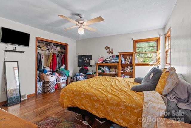 bedroom with ceiling fan, wood-type flooring, and a closet