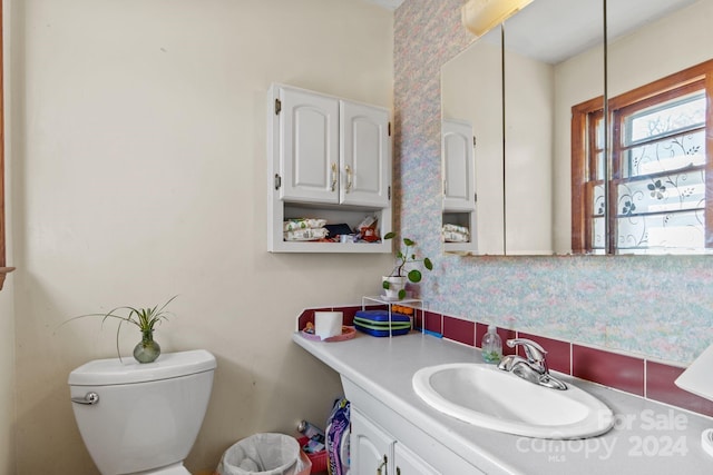 bathroom with vanity, tasteful backsplash, and toilet