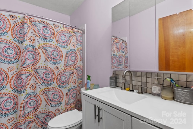 bathroom featuring vanity, a shower with curtain, toilet, a textured ceiling, and tasteful backsplash