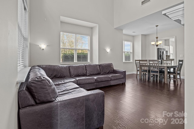 living room featuring a high ceiling, dark hardwood / wood-style floors, and a notable chandelier