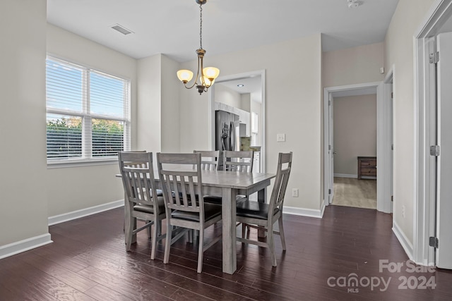 dining space featuring dark hardwood / wood-style flooring and an inviting chandelier