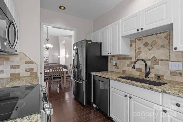 kitchen featuring appliances with stainless steel finishes, sink, a notable chandelier, white cabinets, and dark hardwood / wood-style floors