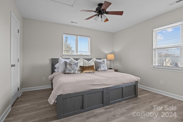 bedroom featuring multiple windows, ceiling fan, and hardwood / wood-style flooring