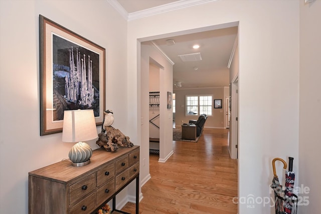 hall with ornamental molding and light hardwood / wood-style floors