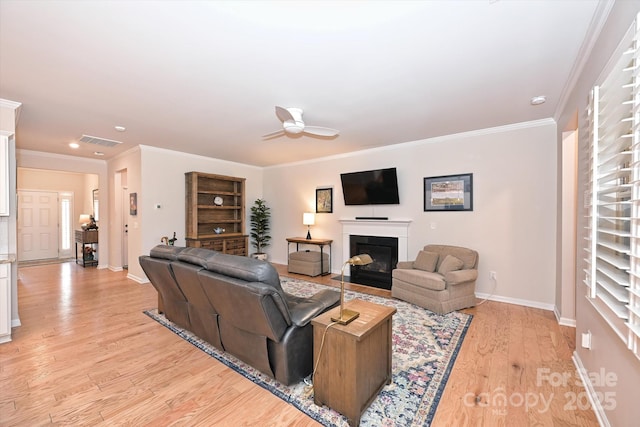 living room featuring ornamental molding, ceiling fan, and light wood-type flooring