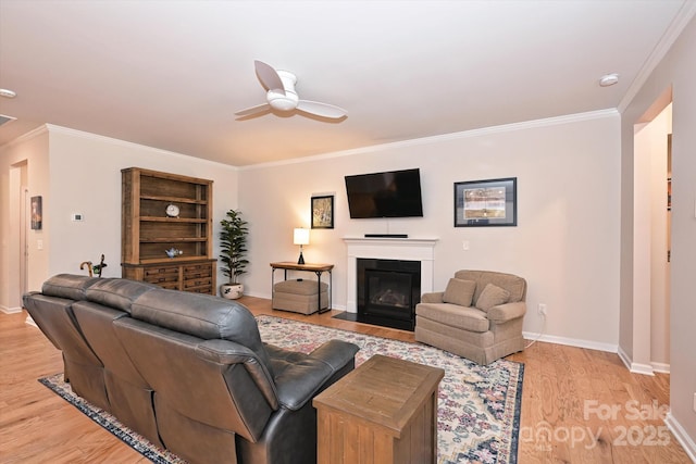 living room featuring crown molding, ceiling fan, and light wood-type flooring