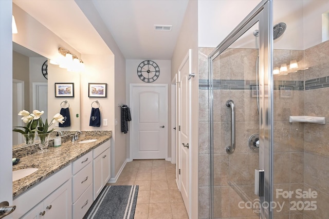 bathroom with tile patterned flooring, vanity, and a shower with door