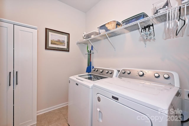 laundry room with washer and clothes dryer and light tile patterned floors