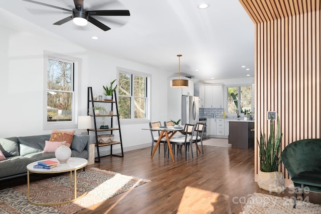 living room with ceiling fan and dark wood-type flooring