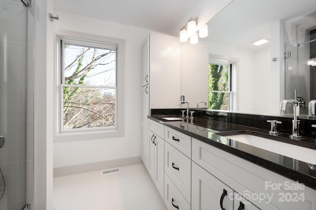 bathroom with tile patterned floors, vanity, and walk in shower