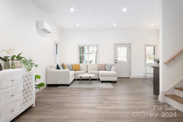 living room with light hardwood / wood-style flooring and a wall mounted AC