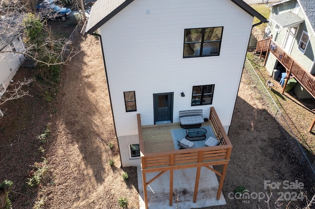 rear view of house featuring a wooden deck