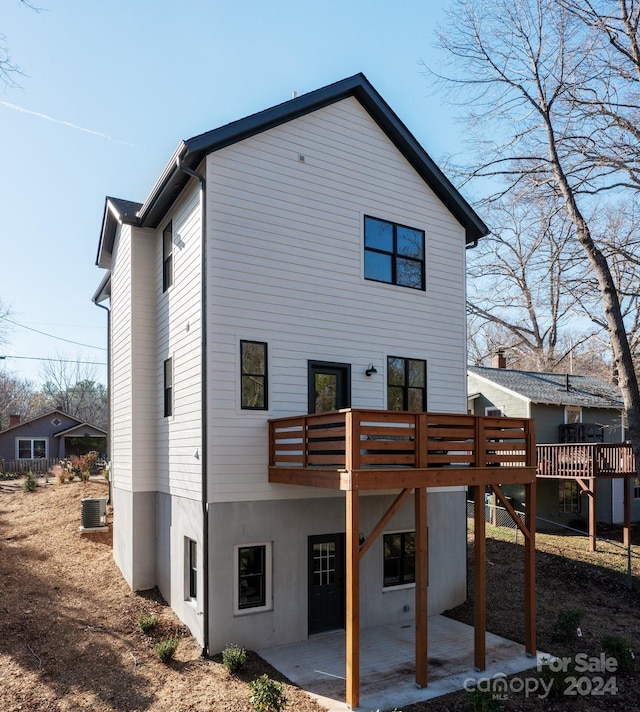 back of house with cooling unit, a patio area, and a wooden deck