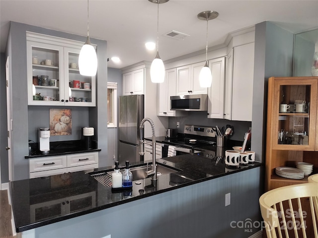 kitchen with white cabinetry, kitchen peninsula, dark stone countertops, decorative light fixtures, and appliances with stainless steel finishes