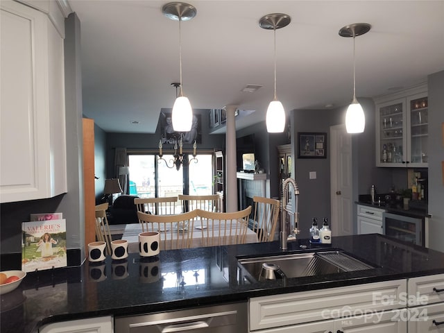 kitchen featuring white cabinetry, sink, pendant lighting, and stainless steel dishwasher