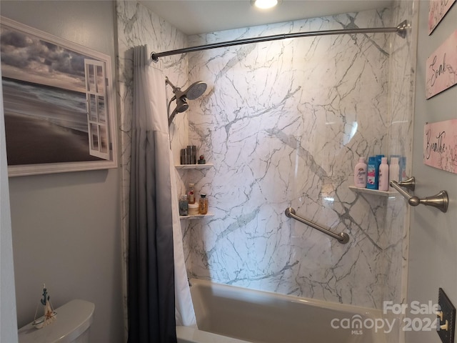 bathroom with shower / bath combo with shower curtain and toilet